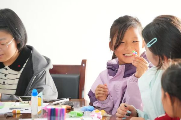 图四 小朋友给志愿者展示她的作品.jpg