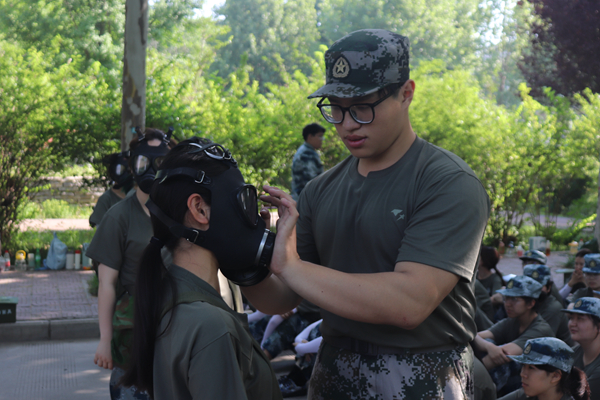 教官帮助学生穿戴防毒面具.JPG