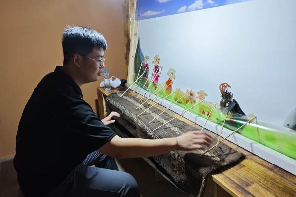 12abc57097b343ce82e9c6fa4f54b537.jpg 队员梁旭辉体验道情皮影.jpg