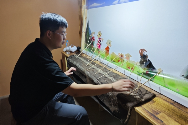 380adf26c5334311aca33dcbabeee571.jpg 图片十 队员梁旭辉体验道情皮影.jpg